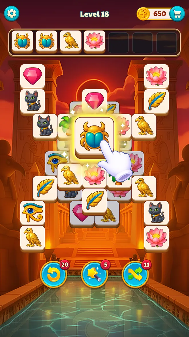 Tile Pyramid: Level 18 vor rotem Tempeltor, vier belegte und drei freie Plätze in der Ablage, der Finger tippt auf eine goldene Skarabäus-Kachel